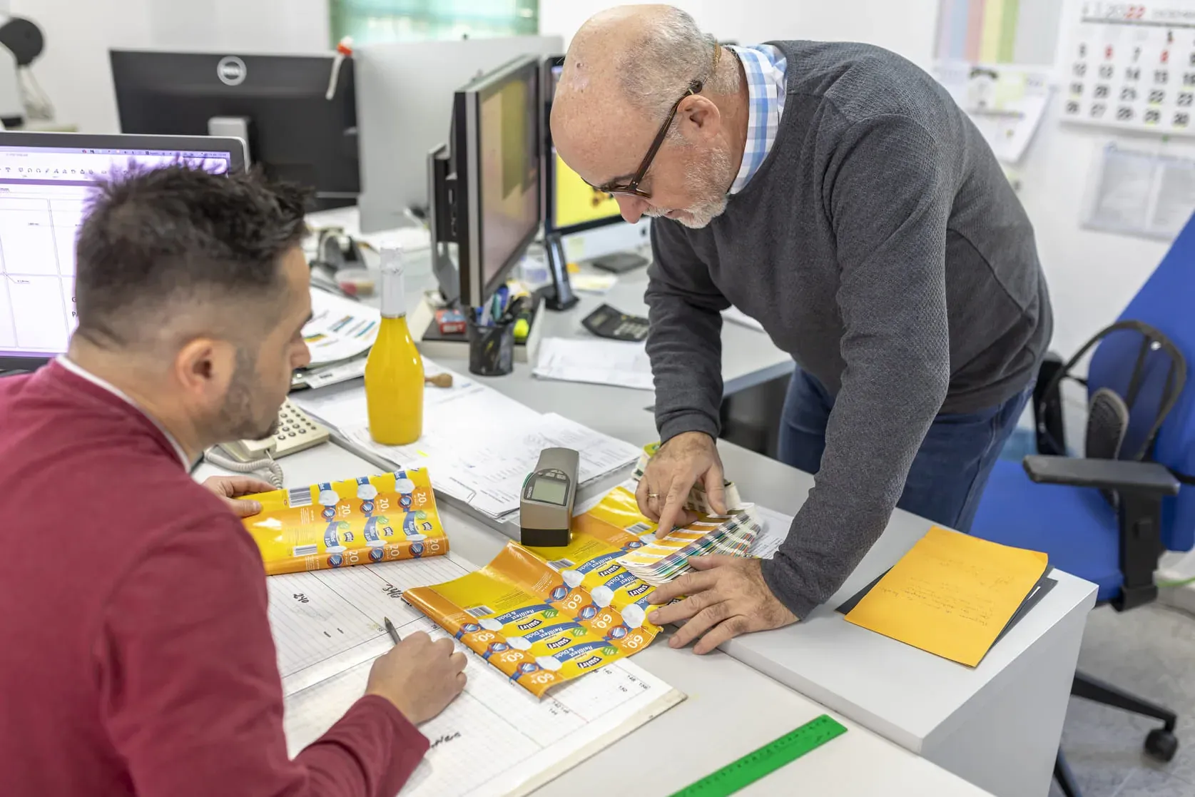 Equipo de preimpresión revisando pruebas de color de etiquetas